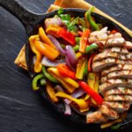 mexican grilled chicken fajitas in iron skillet shot from overhead on slate Mexican Grilled Fajitas